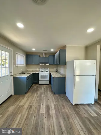 a kitchen with a sink a stove a refrigerator and white cabinets