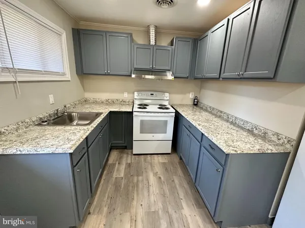 a kitchen with granite countertop kitchen island wooden cabinets a sink and dishwasher