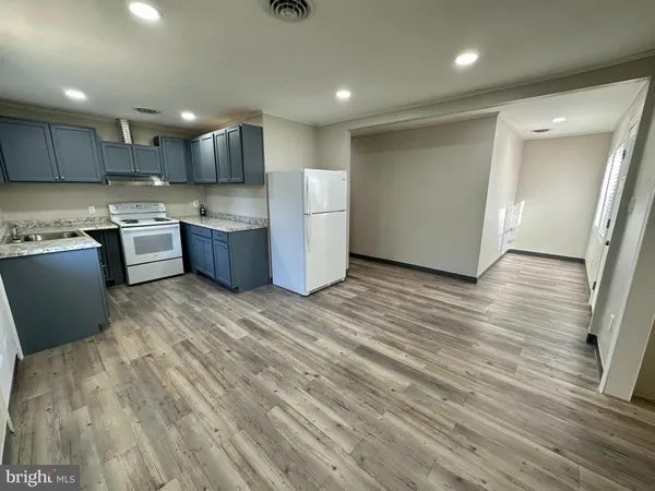 a large kitchen with a lot of cabinets and wooden floor