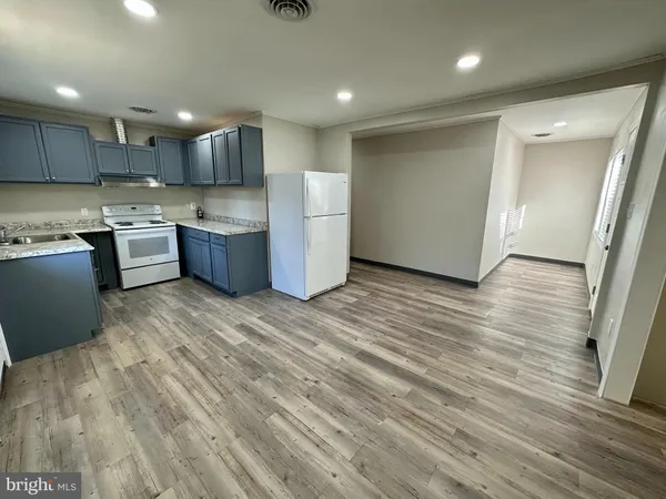 a large kitchen with stainless steel appliances granite countertop a large counter top a sink and a refrigerator