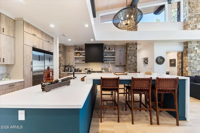 a dining room with wooden floor a chandelier a wooden table and chairs
