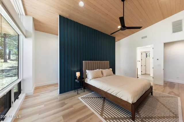 a bedroom with a large bed and a chandelier