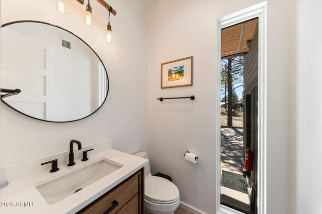 a bathroom with a sink mirror and toilet
