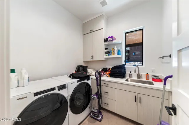 a utility room with sink dryer and washer
