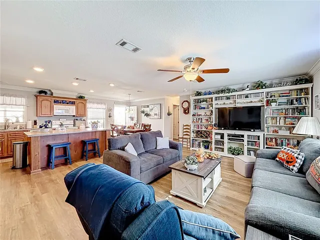 a living room with furniture kitchen view and a flat screen tv