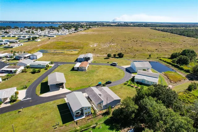 an aerial view of residential houses with outdoor space and ocean view