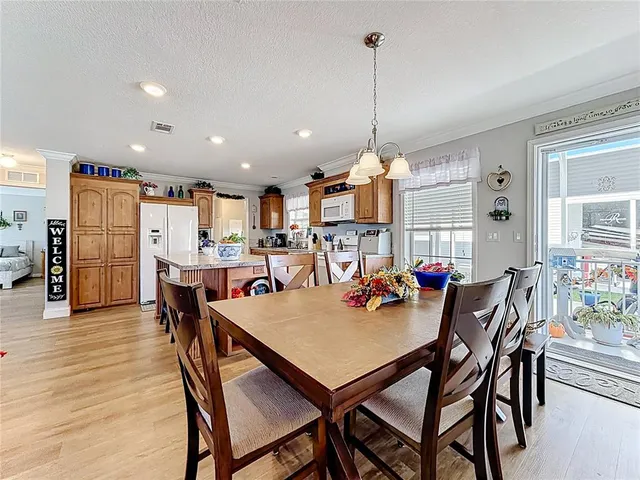 a view of a dining room and livingroom with furniture wooden floor a chandelier
