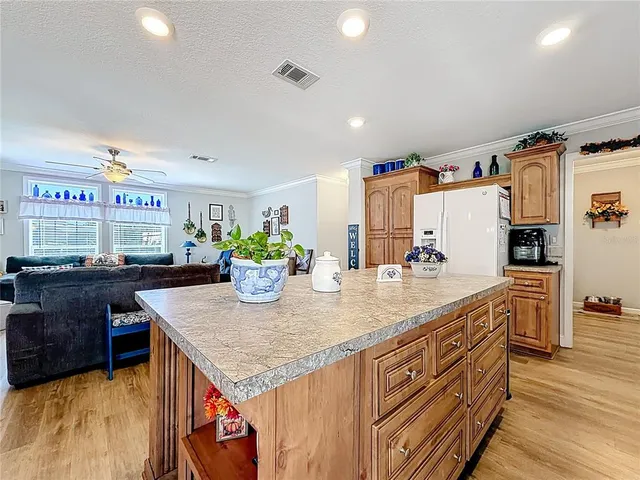 a kitchen with stainless steel appliances granite countertop a sink dishwasher and a refrigerator with wooden floor