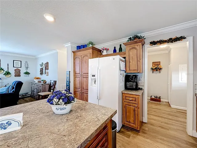 a kitchen with stainless steel appliances granite countertop a refrigerator and wooden floor