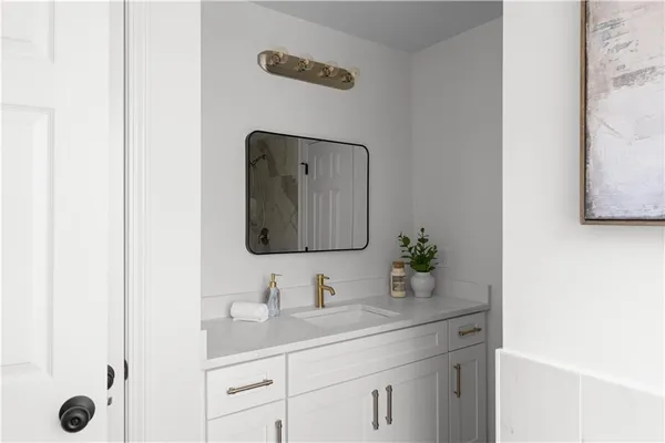 a bathroom with a granite countertop sink and a mirror