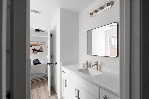 a bathroom with a granite countertop sink vanity and mirror