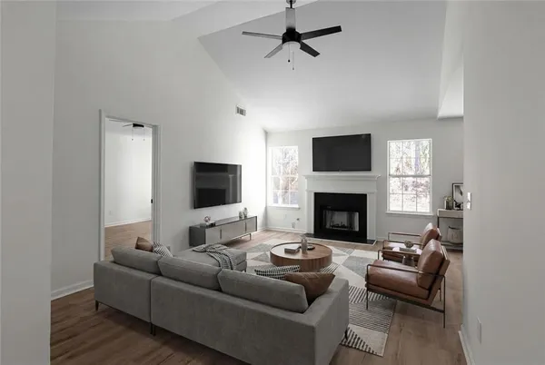 a living room with furniture a flat screen tv and a fireplace