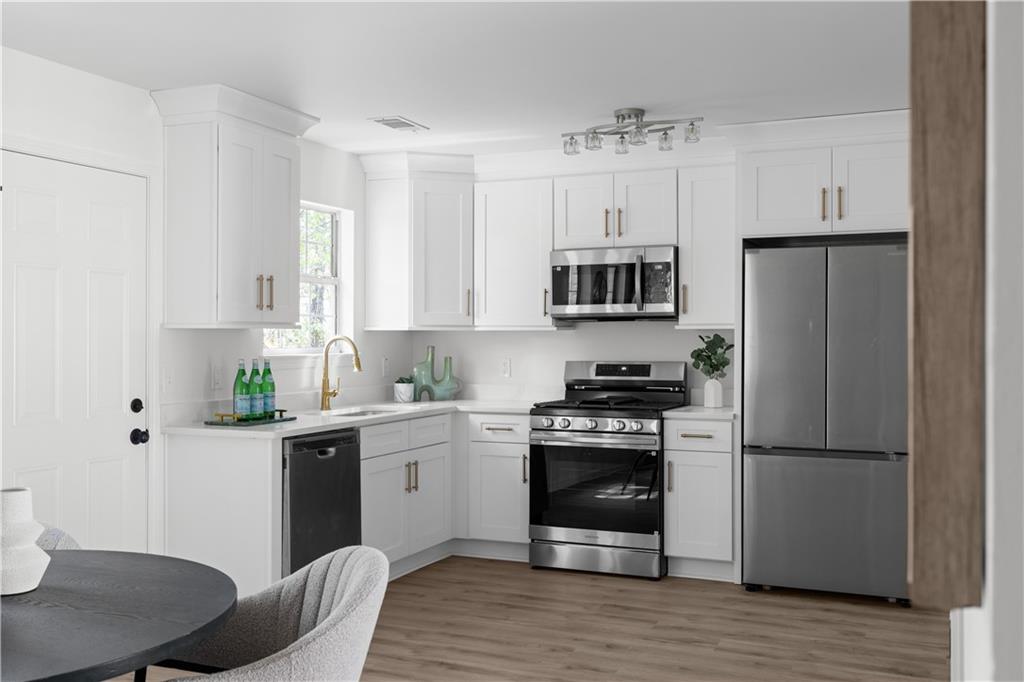 2203 Hidden Creek Drive Decatur, GA 30035 - Photo 10 of 24 a kitchen with cabinets stainless steel appliances and wooden floor