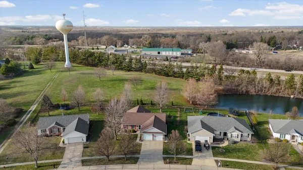 a view of house with a yard and potted plants