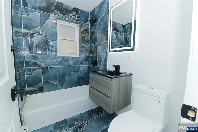 a bathroom with a granite countertop sink toilet and bathtub