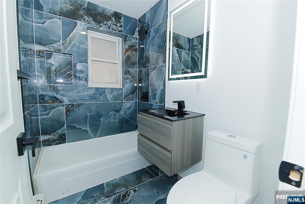 401 Undercliff Avenue Edgewater, NJ 07020 - Photo 11 of 50 a bathroom with a granite countertop sink toilet and bathtub