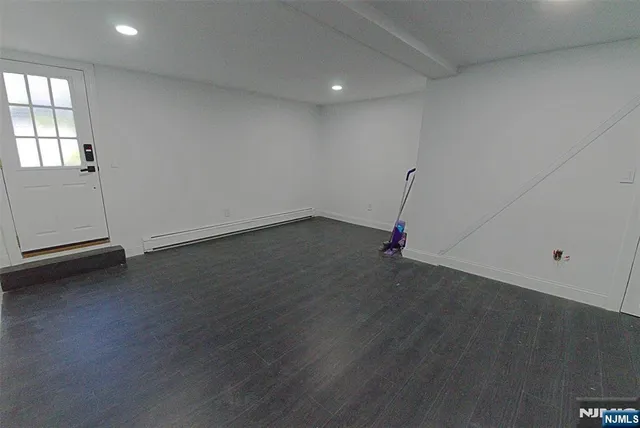 an empty room with wooden floor and white walls