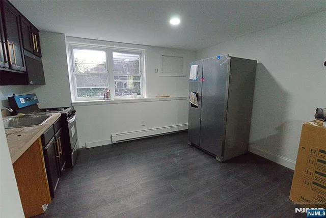 a kitchen with a refrigerator and a stove top oven