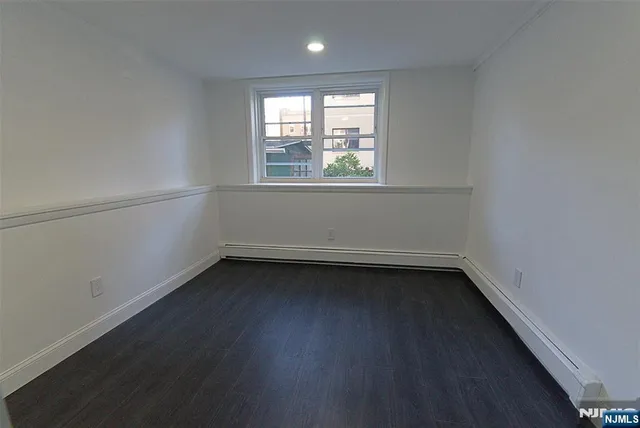 a view of a small space with wooden floor and a window