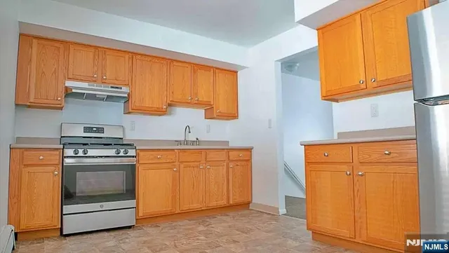 a kitchen with stainless steel appliances granite countertop a stove a sink and a refrigerator