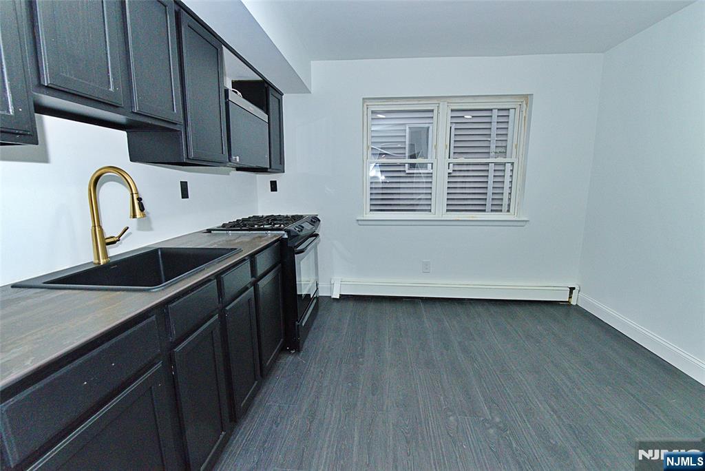 401 Undercliff Avenue Edgewater, NJ 07020 - Photo 5 of 50 a kitchen with stainless steel appliances granite countertop a sink a stove a refrigerator cabinets and wooden floor