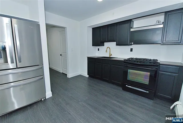 a kitchen with granite countertop a refrigerator stove and microwave