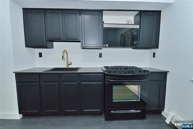a kitchen with granite countertop wood cabinets and stainless steel appliances