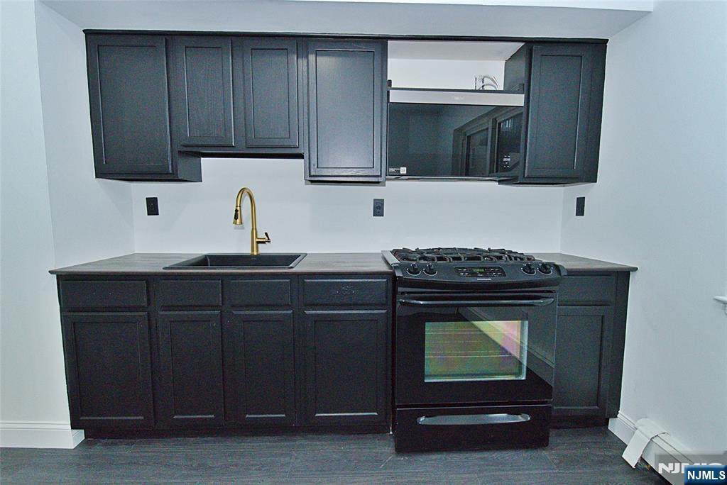 401 Undercliff Avenue Edgewater, NJ 07020 - Photo 7 of 50 a kitchen with granite countertop wood cabinets and stainless steel appliances