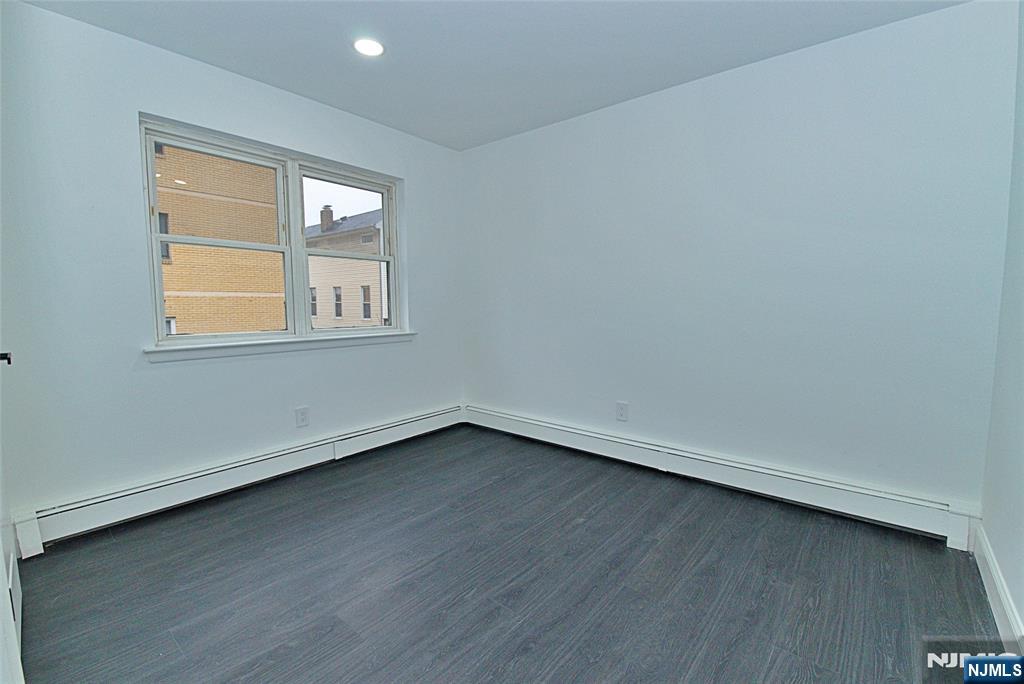 401 Undercliff Avenue Edgewater, NJ 07020 - Photo 9 of 50 an empty room with wooden floor and windows