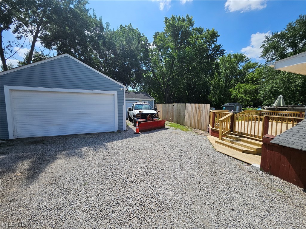 753 West River Road North Elyria, OH 44035 - Photo 23 of 28 Expansive gravel driveway leading to a two-car garage with light blue siding