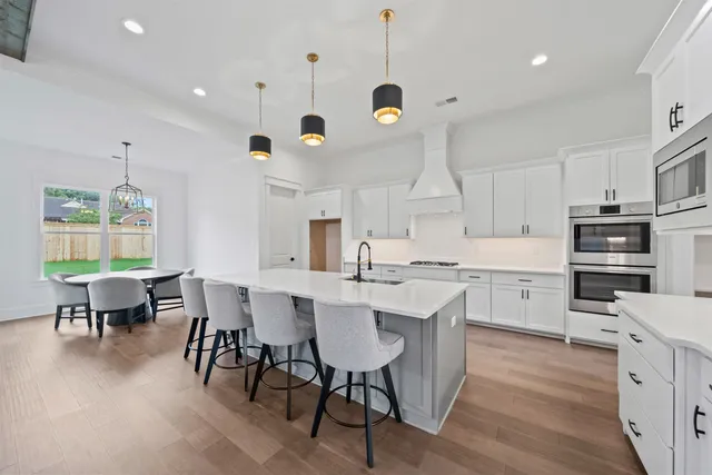 a kitchen with a dining table chairs stainless steel appliances and cabinets