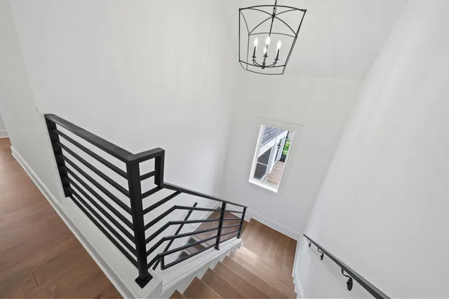 a view of a hallway with wooden floor and a staircase