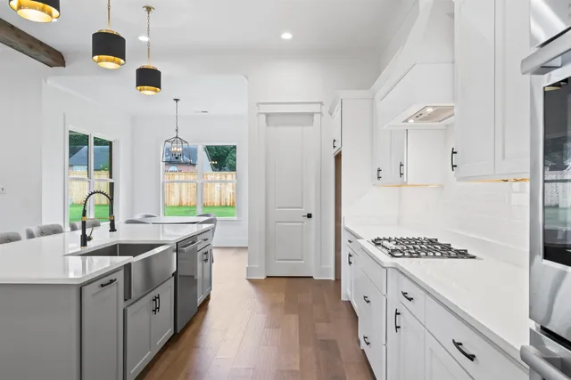 a kitchen with stainless steel appliances a stove a sink and a refrigerator