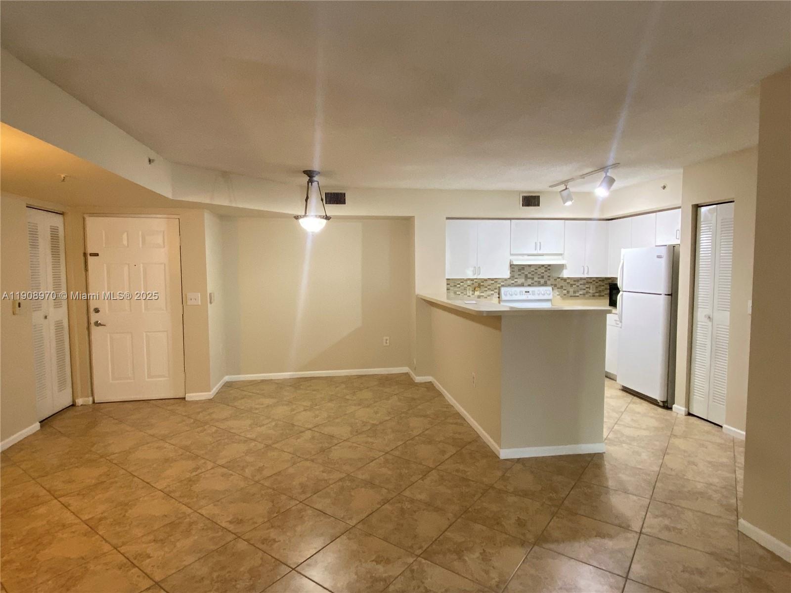2173 Renaissance Boulevard, Unit 105 Miramar, FL 33025 - Photo 2 of 16 a view of a kitchen with kitchen island wooden floor center island stainless steel appliances and cabinets