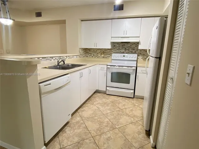 a kitchen with a stove a sink and a refrigerator