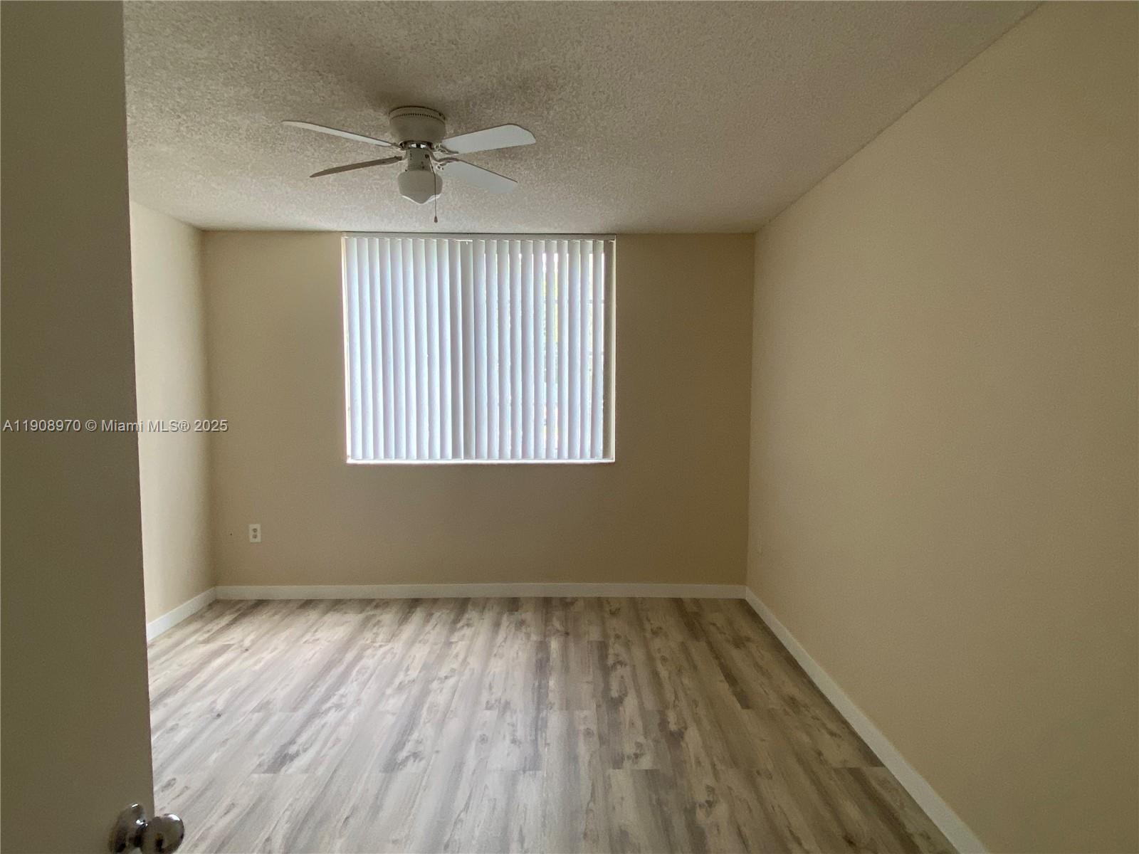 2173 Renaissance Boulevard, Unit 105 Miramar, FL 33025 - Photo 6 of 16 wooden floor in an empty room with a window