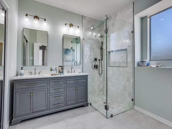 a bathroom with a double vanity sink mirror and shower