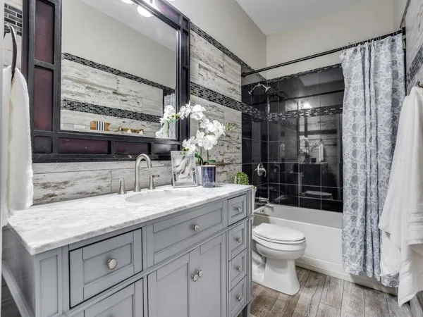 a bathroom with a granite countertop sink toilet and shower