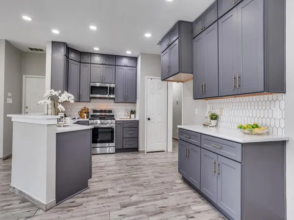 a kitchen with kitchen island a sink stainless steel appliances and cabinets