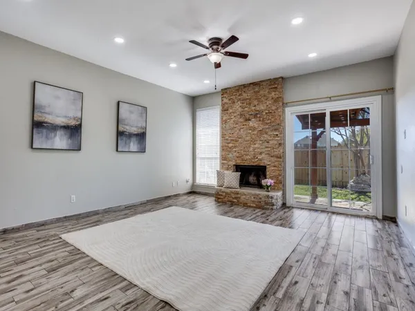 a view of an empty room with a fireplace and a window
