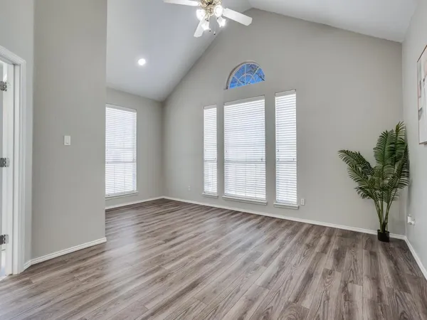 an empty room with wooden floor and a window