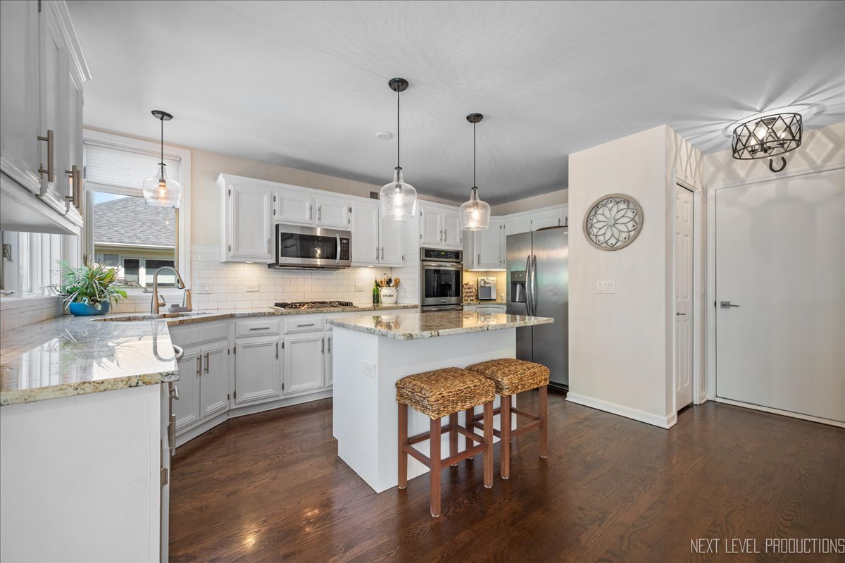 710 Hampton Course West Chicago, IL 60185 - Photo 11 of 28 a kitchen with stainless steel appliances granite countertop a kitchen island a stove a table and chairs