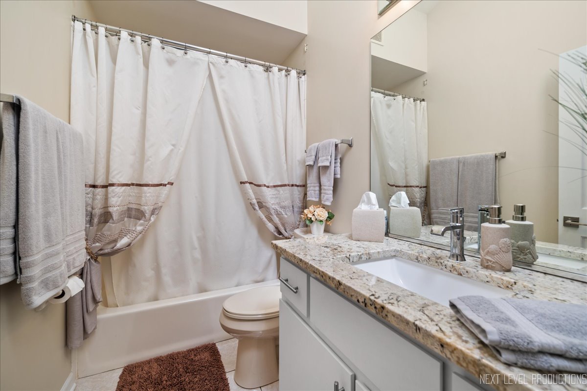 710 Hampton Course West Chicago, IL 60185 - Photo 16 of 28 a bathroom with a granite countertop sink toilet and shower