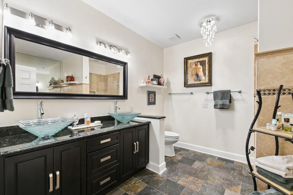 2921 Lenox Road Northeast, Unit 103 Atlanta, GA 30324 - Photo 22 of 37 a bathroom with a toilet sink and mirror
