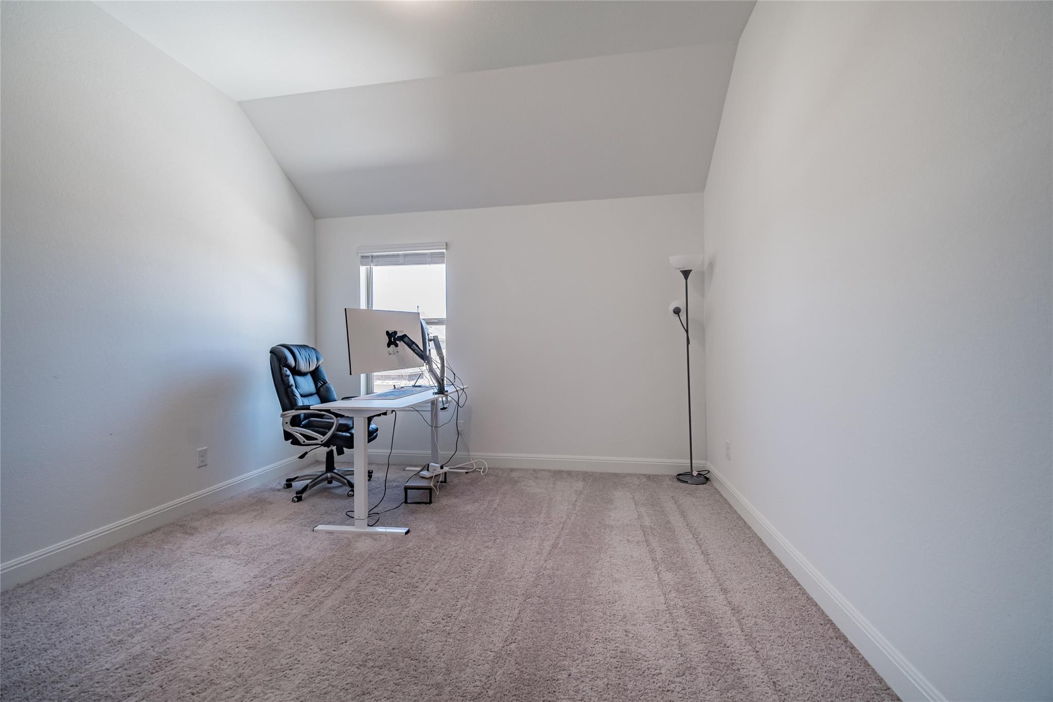 3049 Sage Ranch Drive Leander, TX 78641 - Photo 6 of 23 An airy office space offers vaulted ceilings, soft carpeting, and a sun-filled window, perfect for productivity.