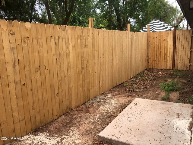 a view of a backyard with wooden fence