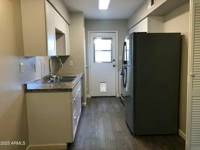 a kitchen with a refrigerator and a sink