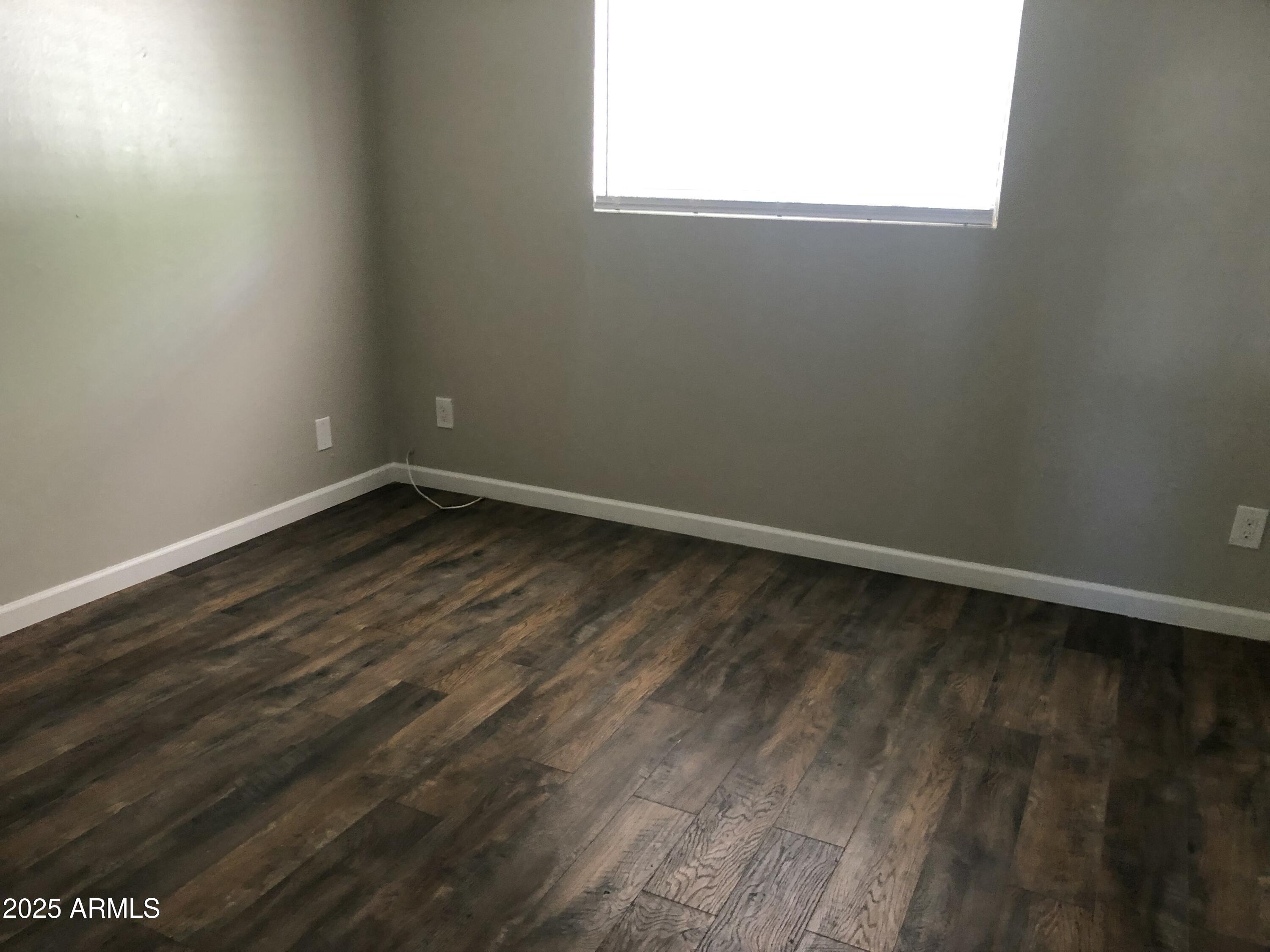 520 West Clark Street, Unit 8 Mesa, AZ 85201 - Photo 4 of 7 a view of an empty room with wooden floor and a window