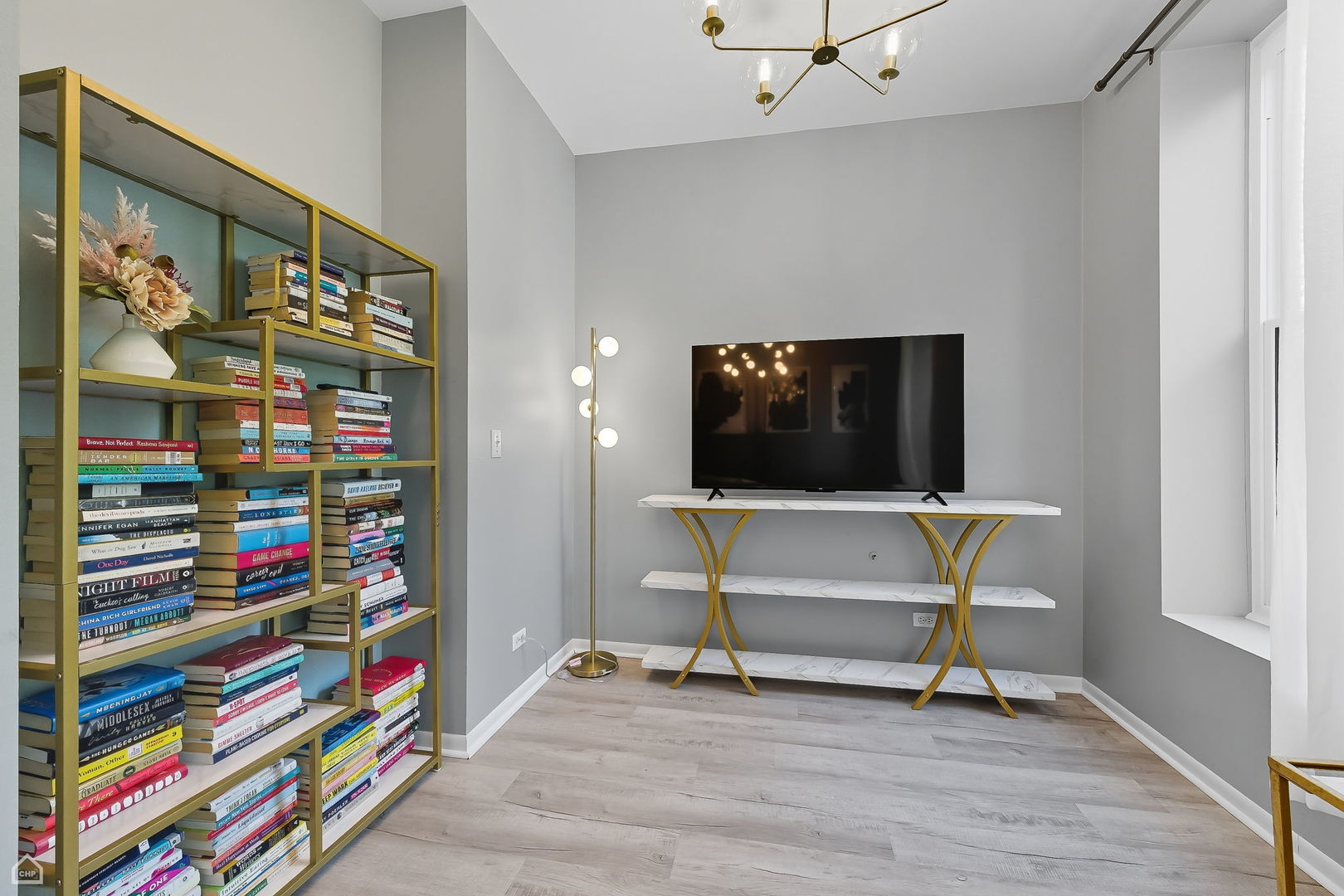 2245 West Erie Street Chicago, IL 60612 - Photo 5 of 25 a living room with a bookshelf and a flat screen tv