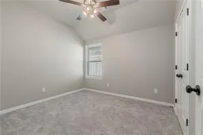 an empty room with a chandelier fan and windows